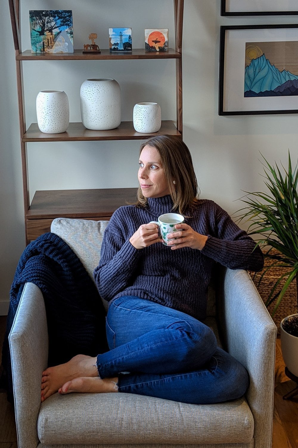 Vanessa sitting in a chair with a cup of tea looking out the window