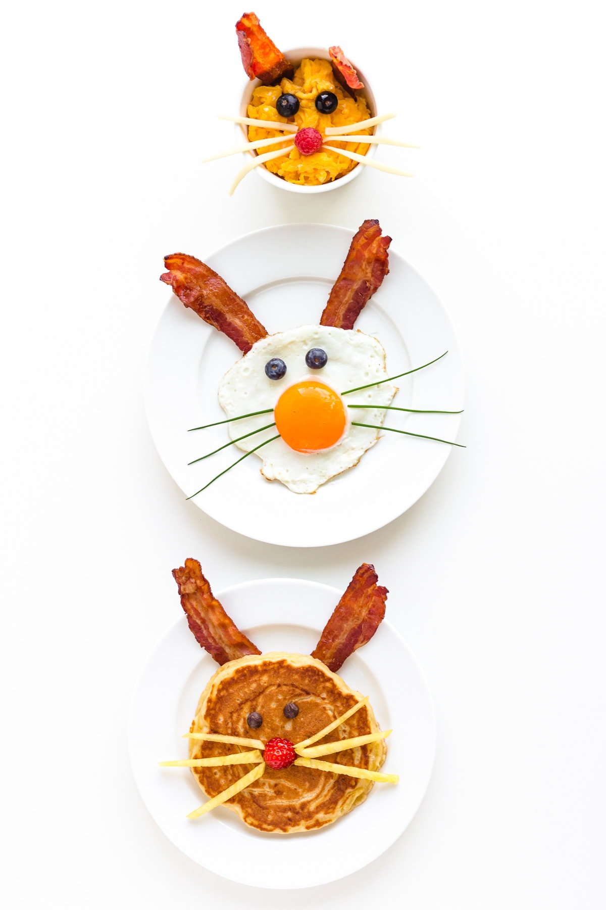 Three versions of an Easter Bunny themed breakfast displayed on a white background.  Easter Bunny pancake, fried egg bunny and scrambled egg bunny.