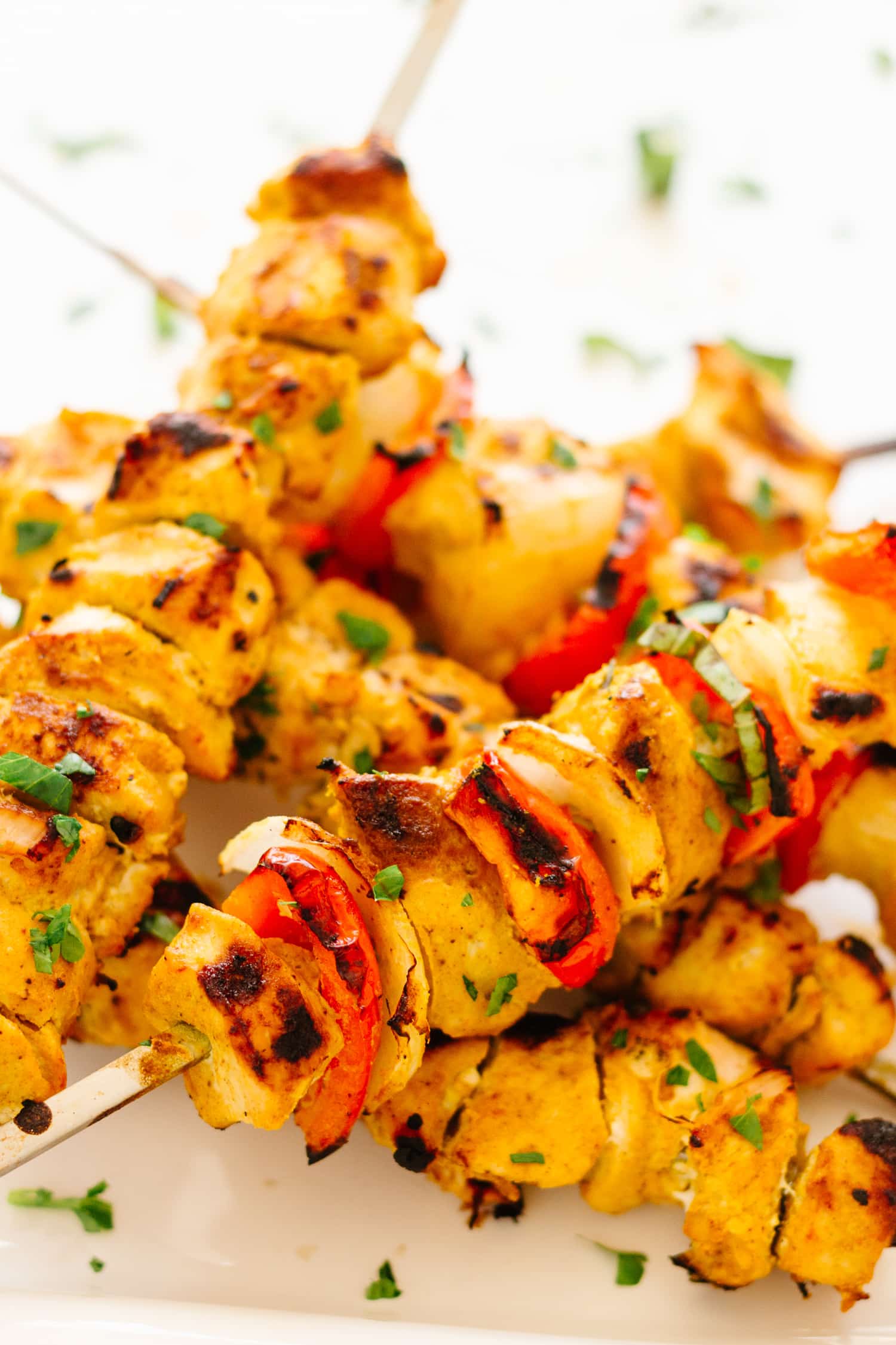 Pile of Grilled Tandoori Chicken Kebabs on a white plate