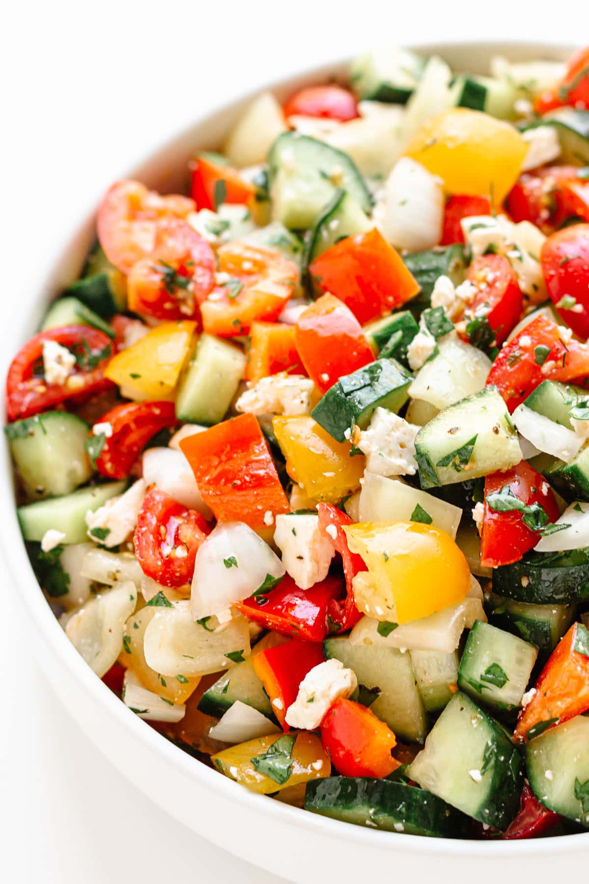 Bowl of Mediterranean style chopped salad on a white background.