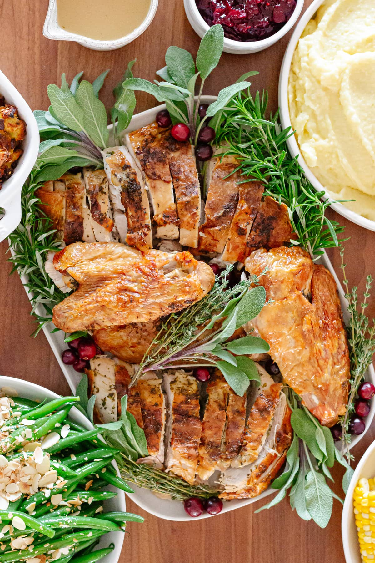 Overhead of a Thanksgiving turkey dinner set out on a wood table.