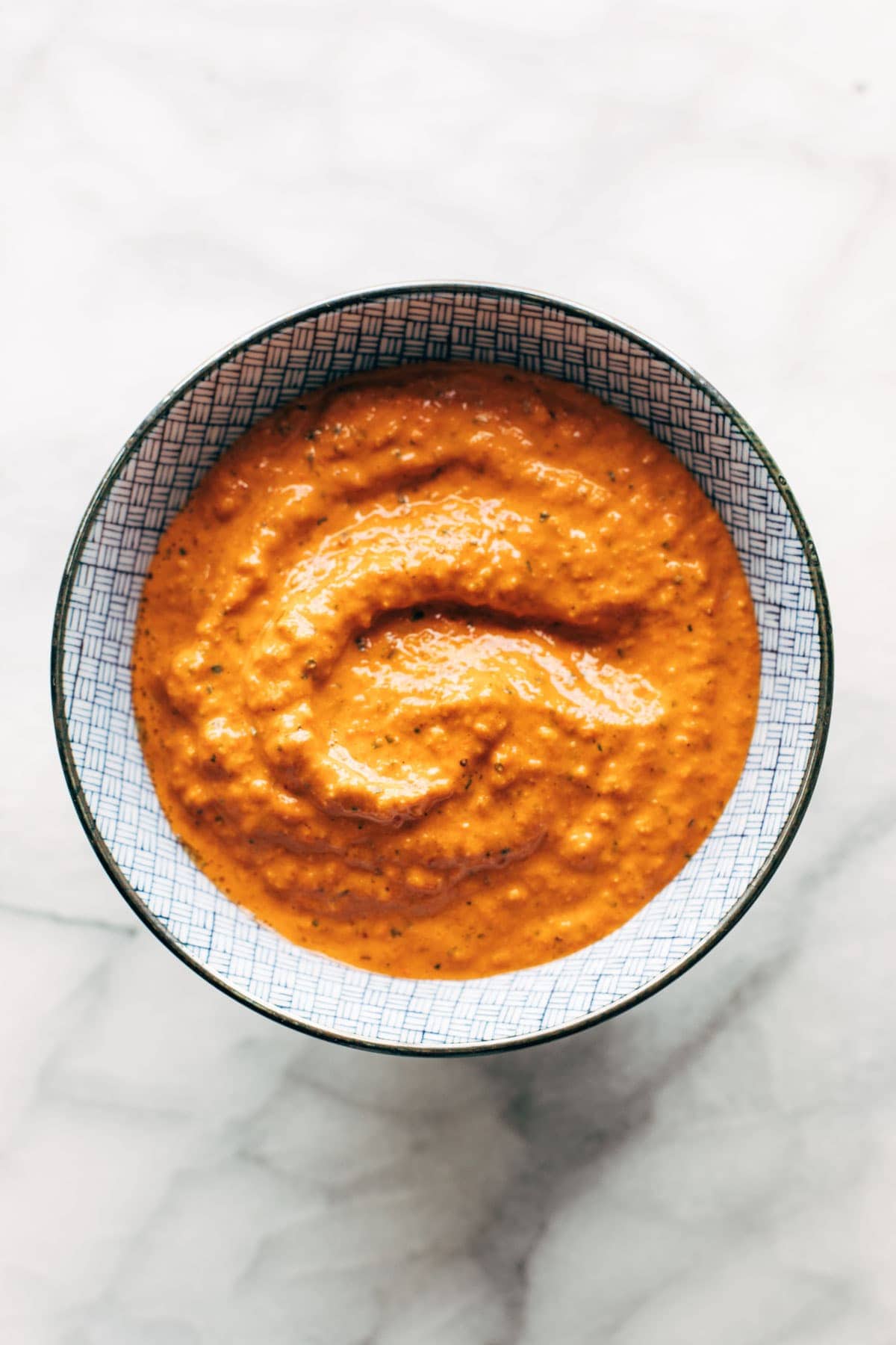 Roasted red pepper sauce in a bowl on a white background