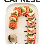 Photo of a caprese salad in the shape of a candy cane with text overlay that reads "Candy Cane Caprese".