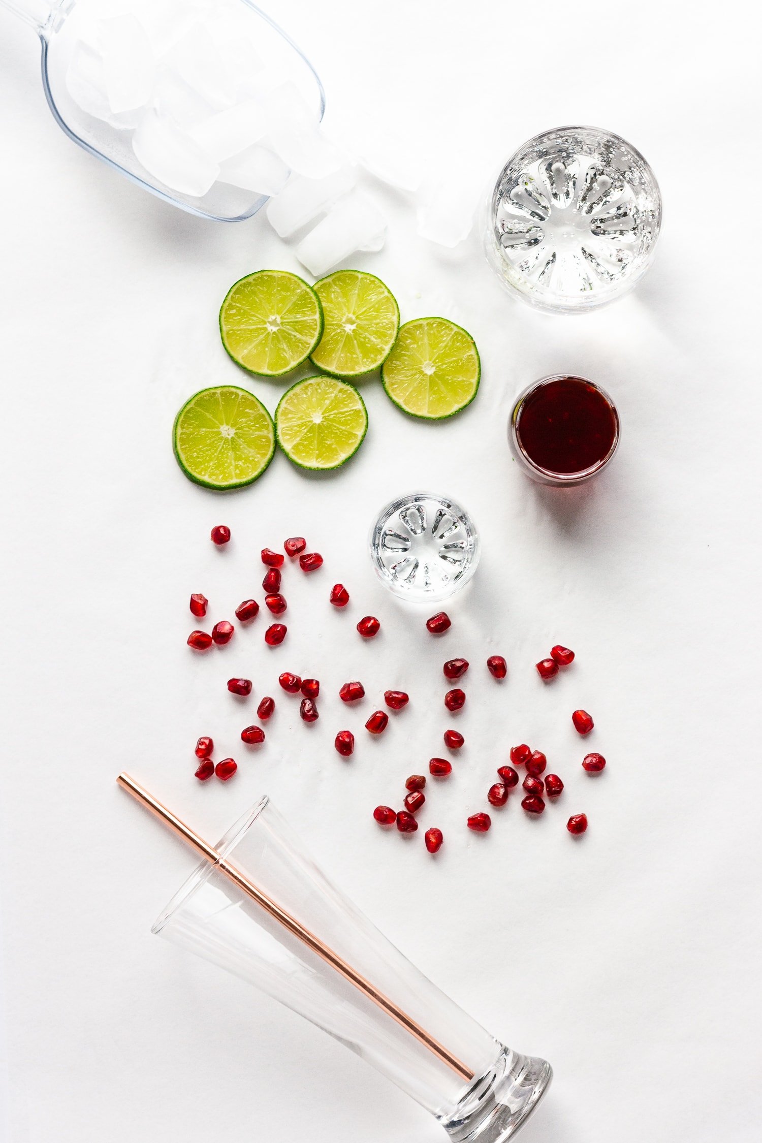 Overhead shot of all the ingredients needed to make the Pomegranate Lime Spritzer cocktail recipe