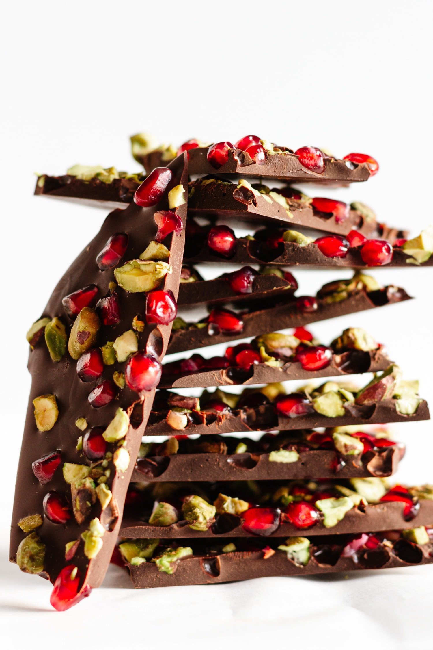 Pomegranate and pistachio dark chocolate bark stacked.