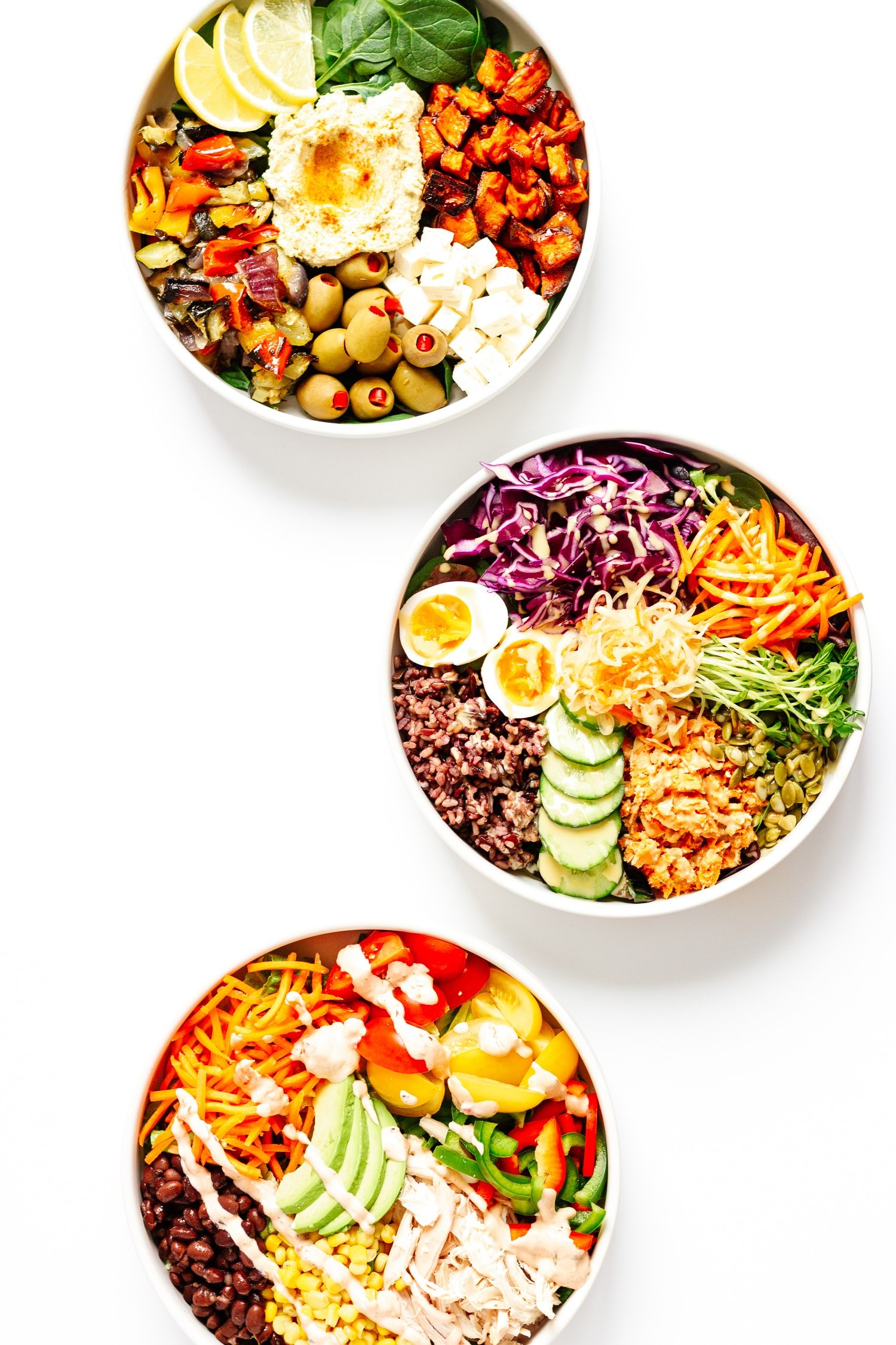 Three different healthy nourish bowls on a white background.