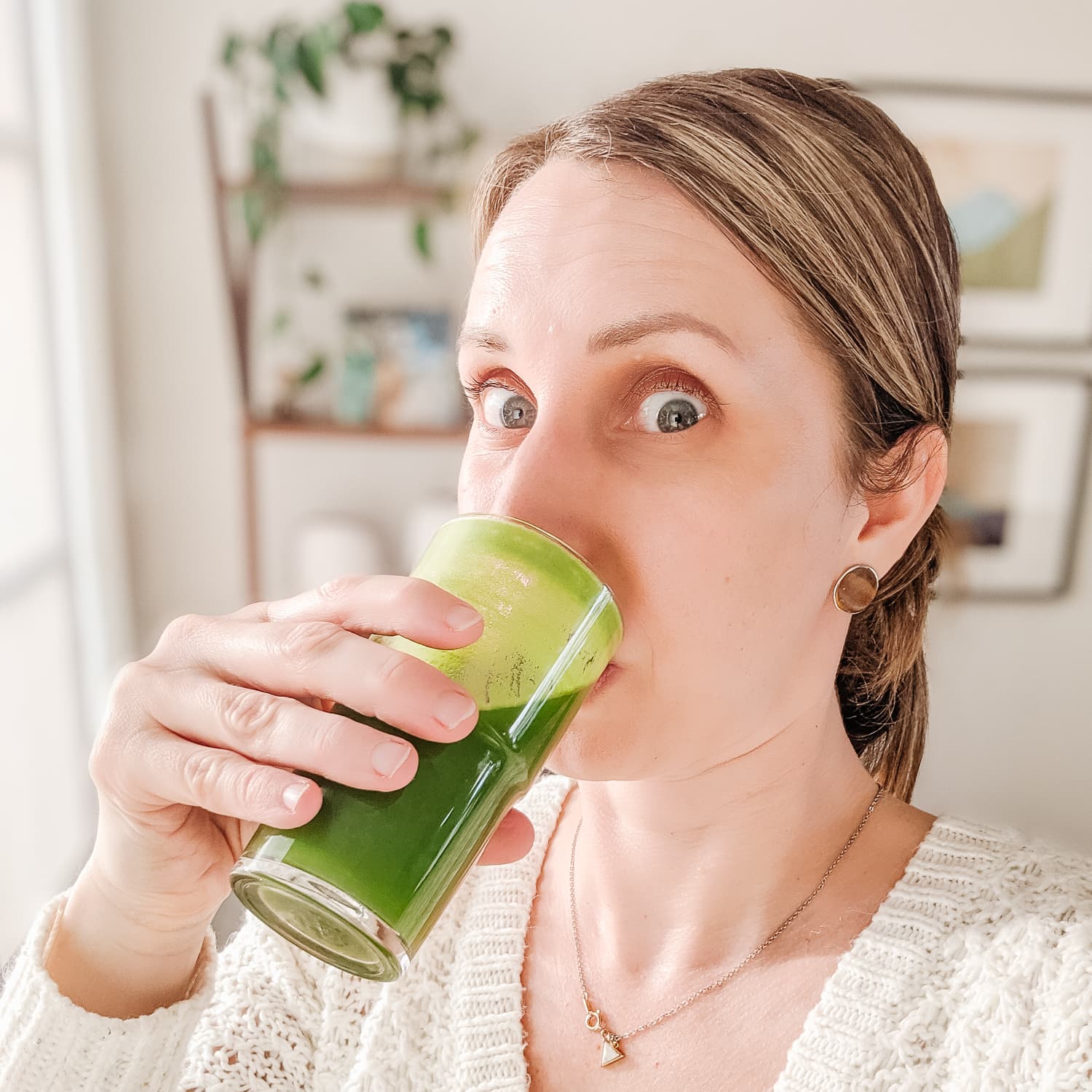 Vanessa from Maple + Mango drinking a glass of green juice.