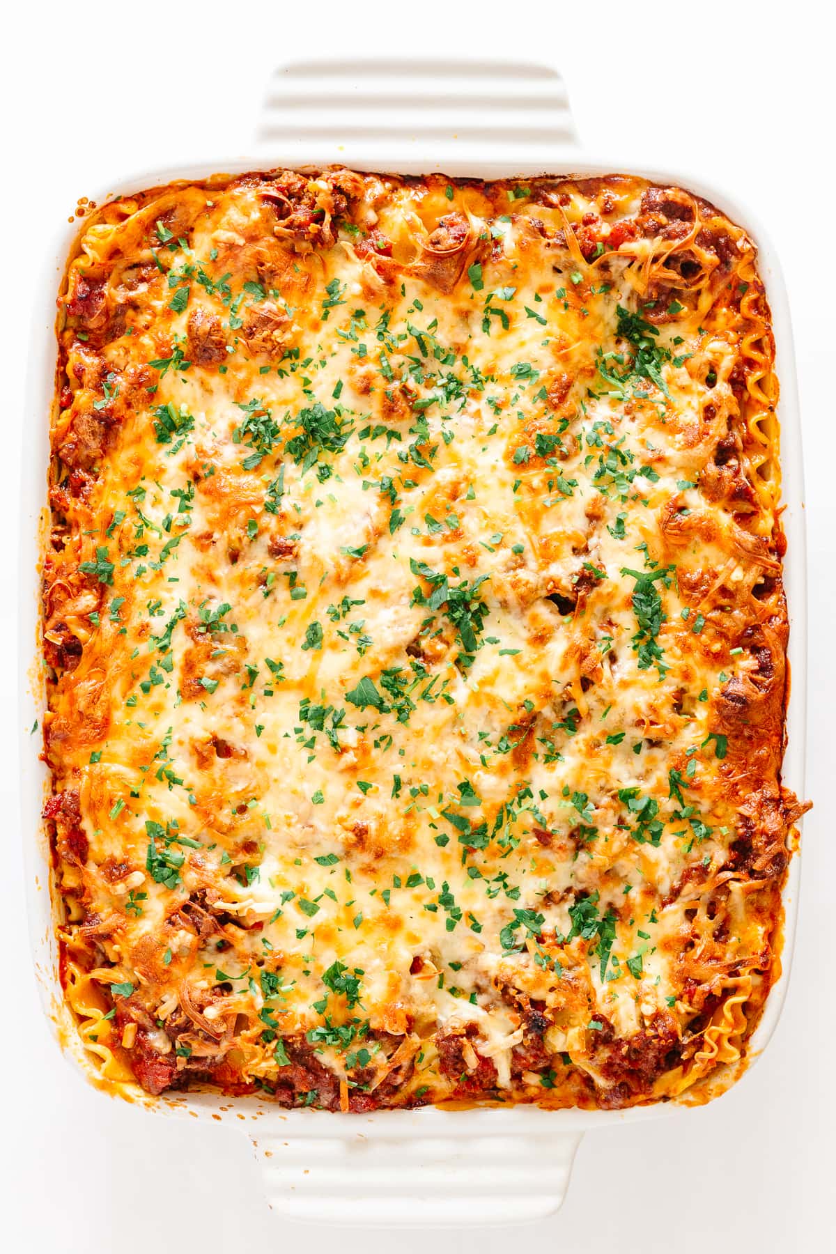 Lasagna in a white dish on a white background