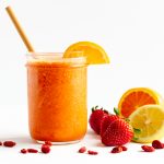 Vitamin C Smoothie in mason jar with bamboo straw and fruit scattered next to it