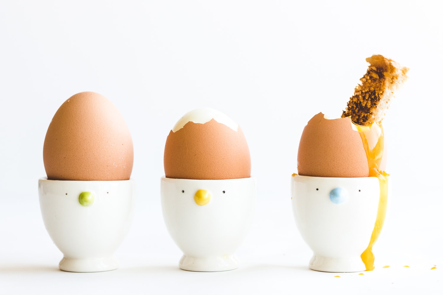 Three soft boiled eggs in egg cups.