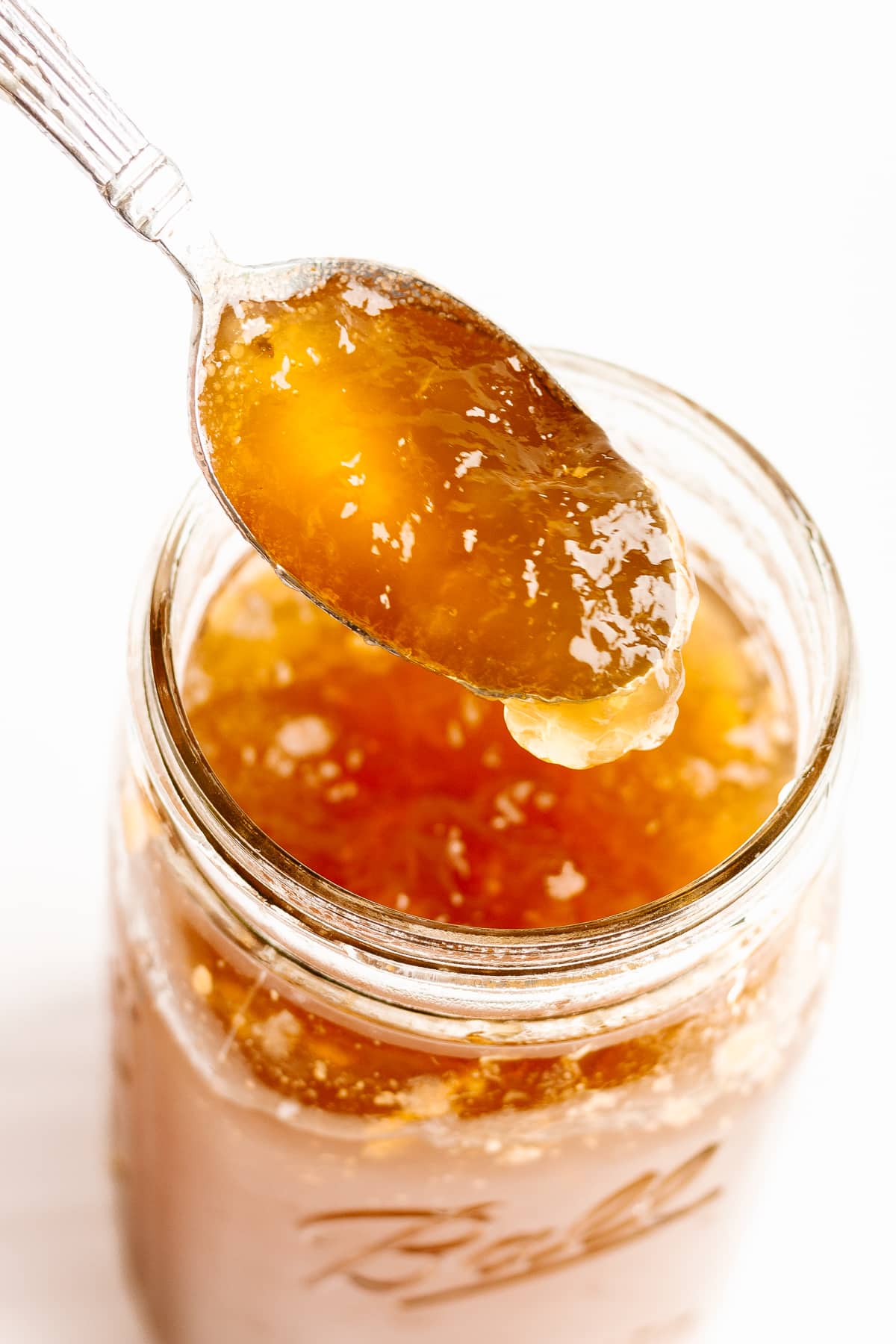 Spoonful of chilled bone broth being lifted out of a glass mason jar.