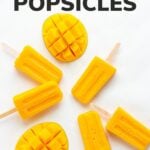 Popsicles and fresh mango on a white background with text overlay "Mango Popsicles"