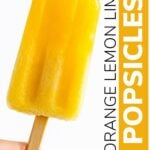 Hand holding a popsicle with text overlay "Orange Lemon Lime Popsicles".
