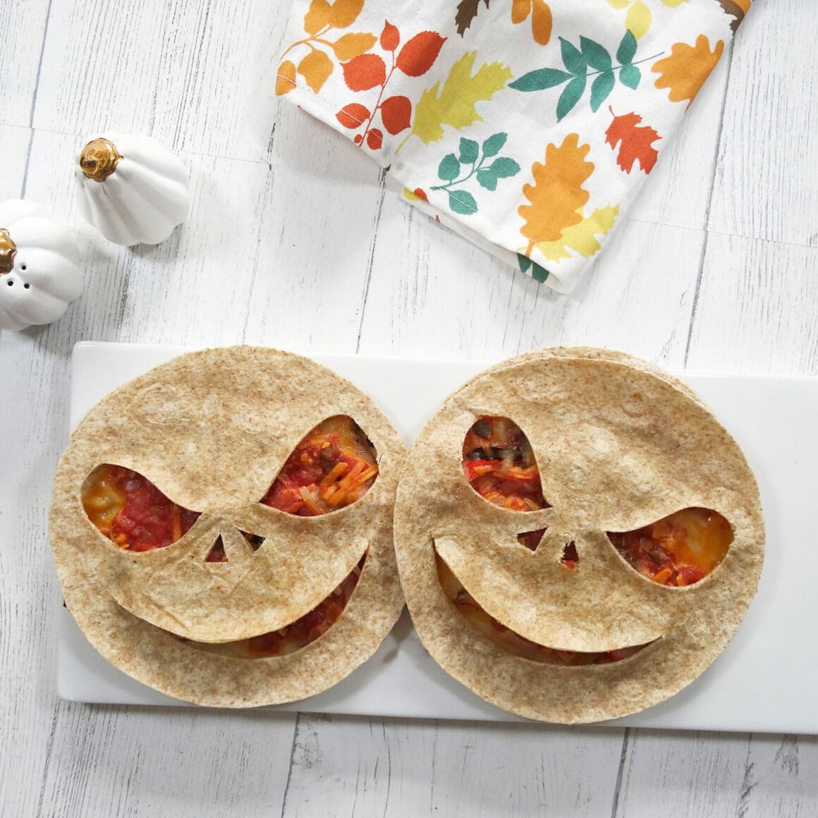 Two quesadillas with creepy faces carved into them for Halloween.