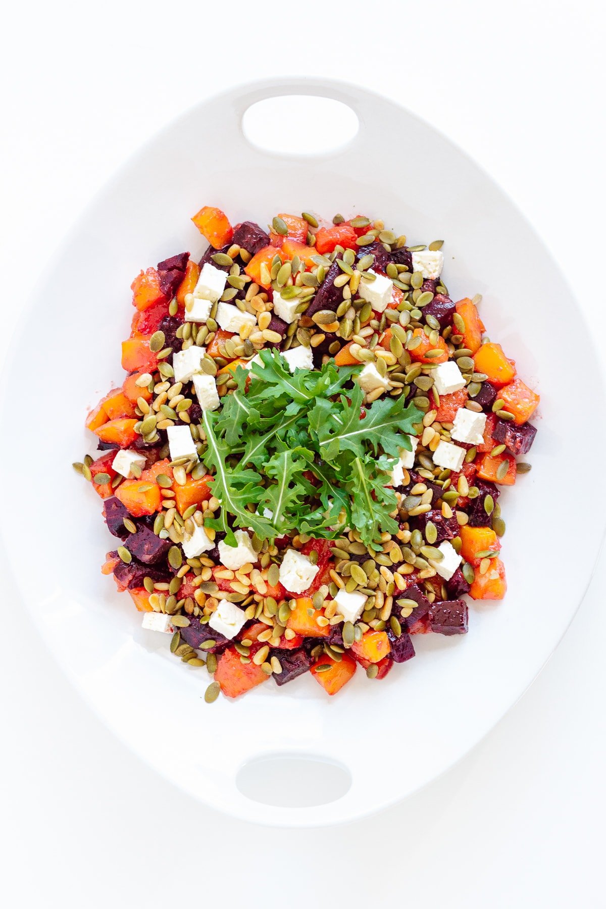 Roasted pumpkin and beetroot salad on a white serving platter.