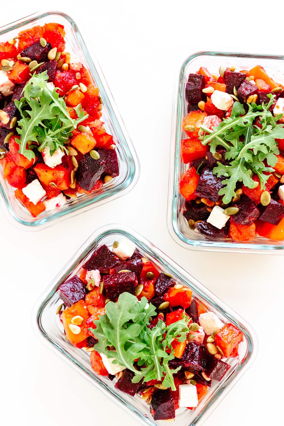 Three glass meal prep containers containing roasted pumpkin, beetroot and feta salad.