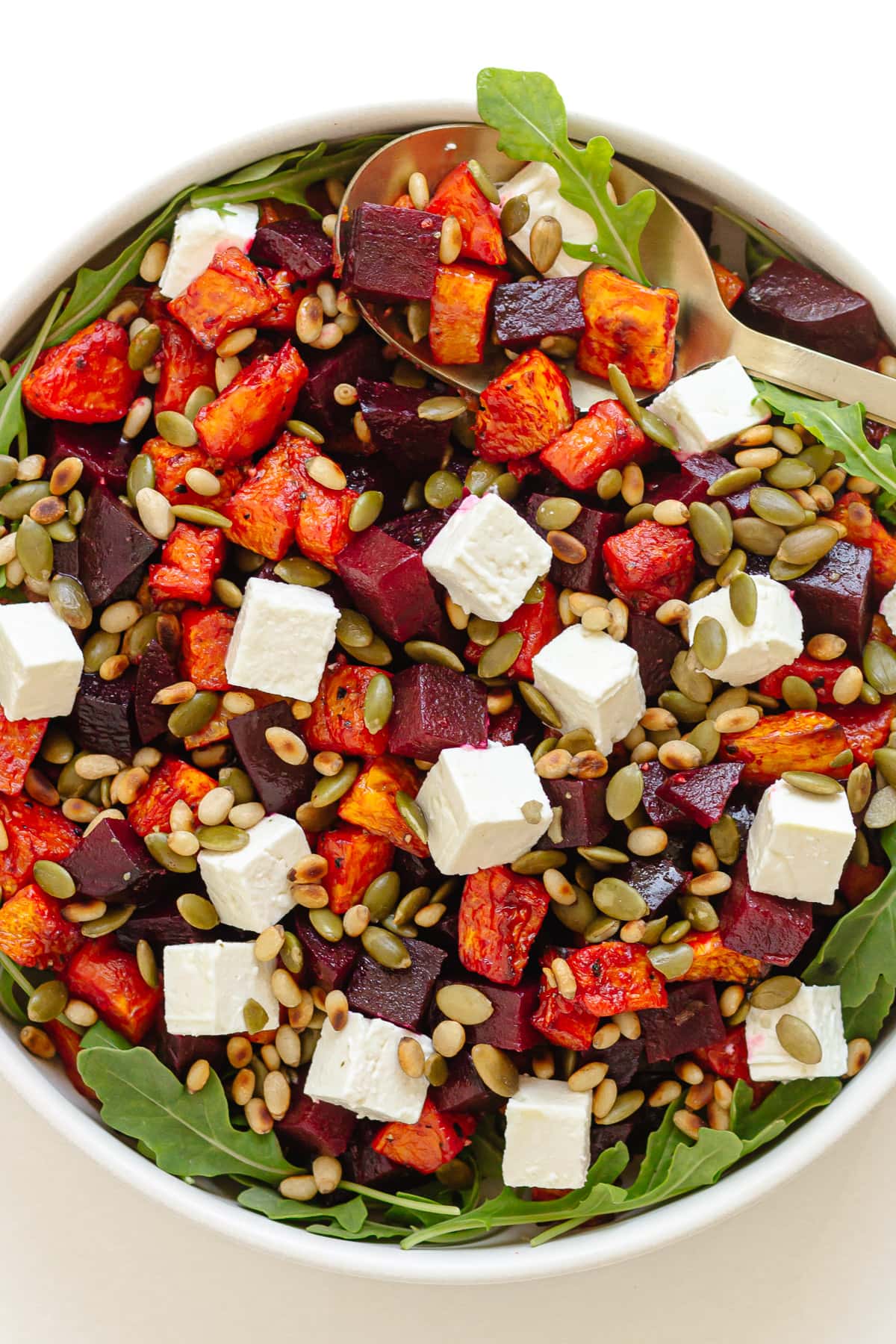 Roast pumpkin and beetroot salad in a white serving bowl.