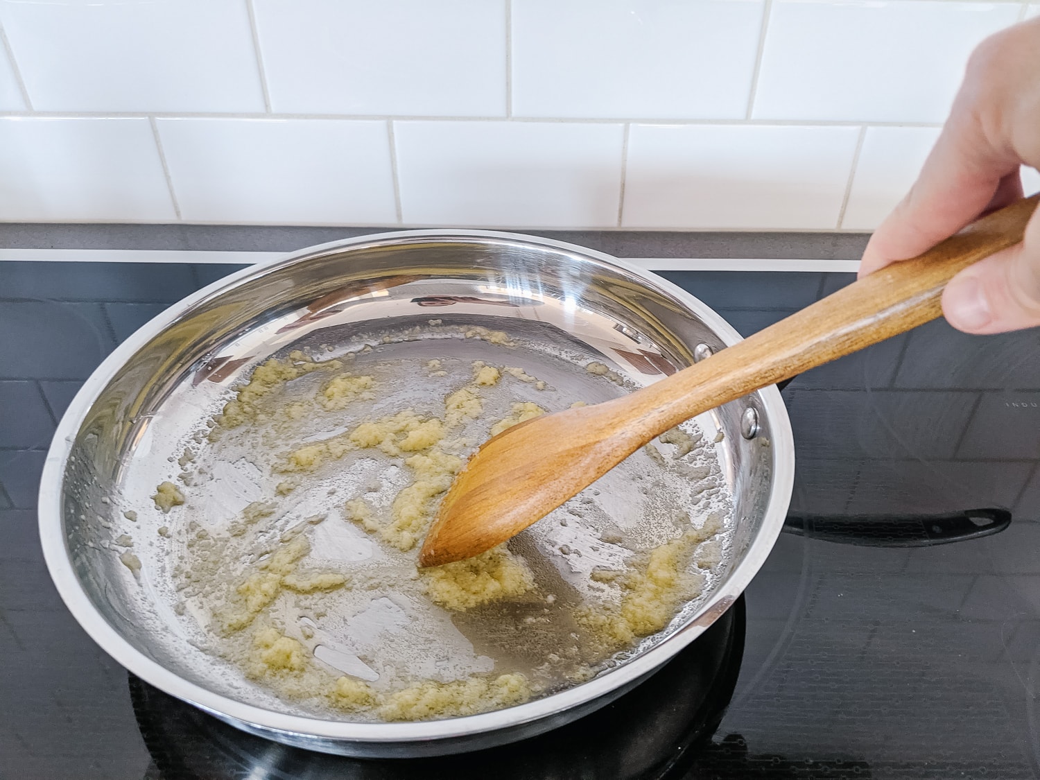 Sauteeing garlic in butter in a large frying pan.