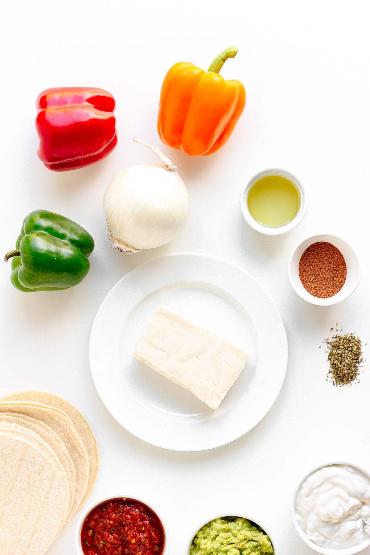 Flat lay of ingredients needed to make halloumi fajitas on a white background.