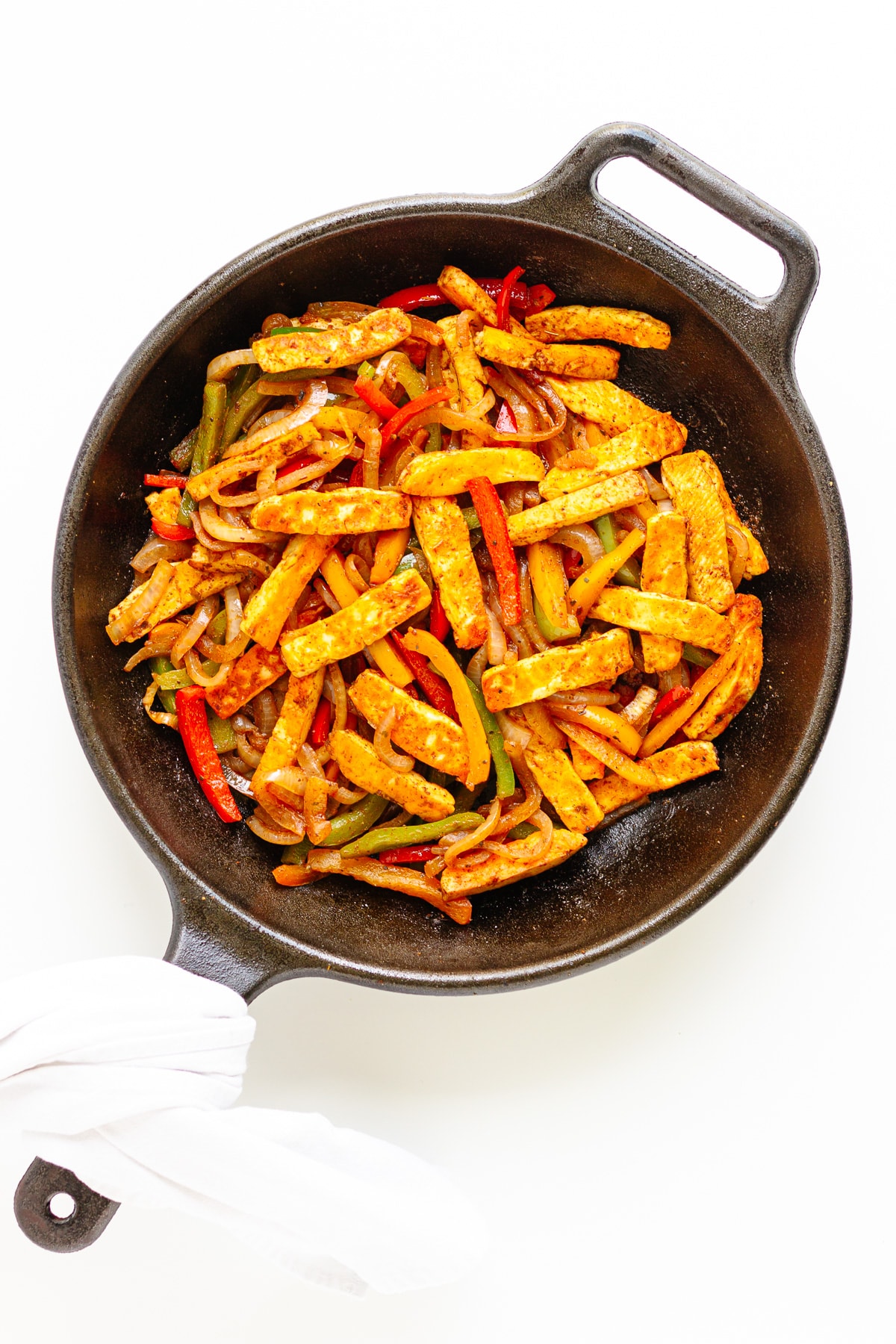 Fajita veggies with pan fried halloumi strips in a cast iron skillet.