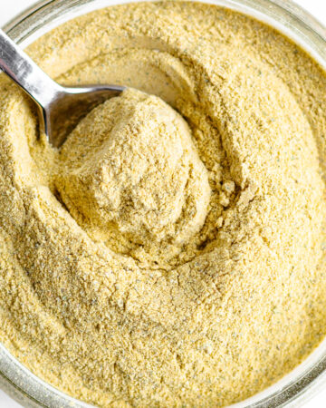 Homemade vegetarian "chicken" bouillon powder in a jar with spoon.