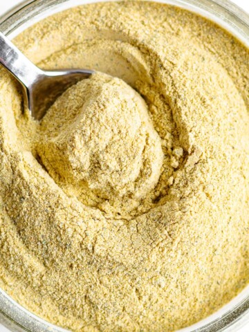 Homemade vegetarian "chicken" bouillon powder in a jar with spoon.