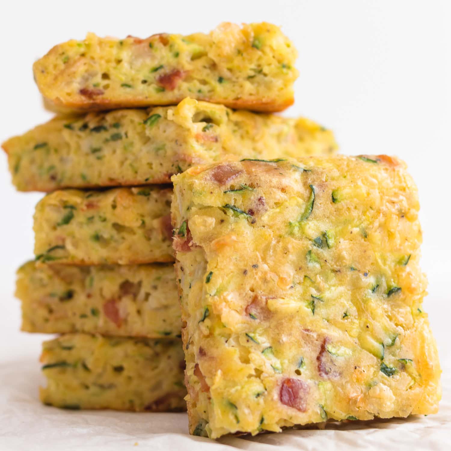 Pile of zucchini slice with one piece leaning against it.