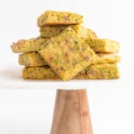 Pile of zucchini slice on a marble and wood cake stand.