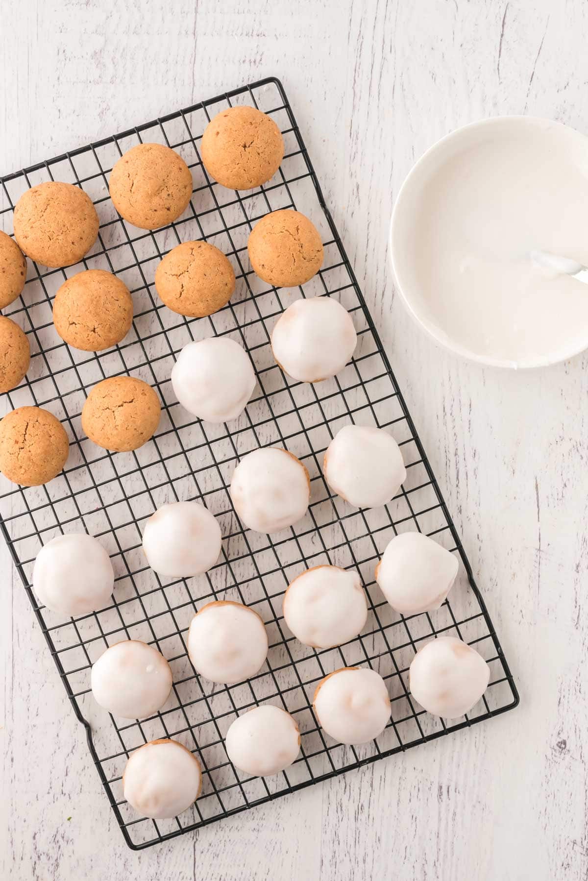 Pfeffernüsse on a wire cooling rack, some with glaze and some without.