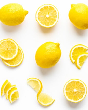 Flat lay of lemons cut in different ways on a white background.