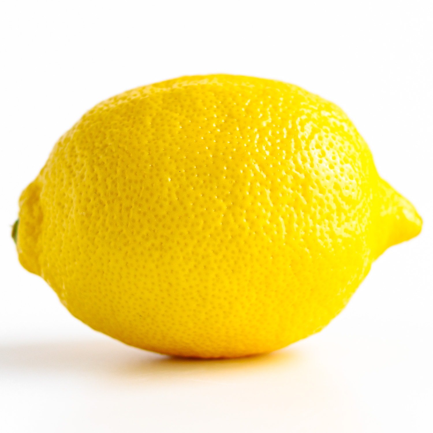 Closeup of one lemon against a white background.
