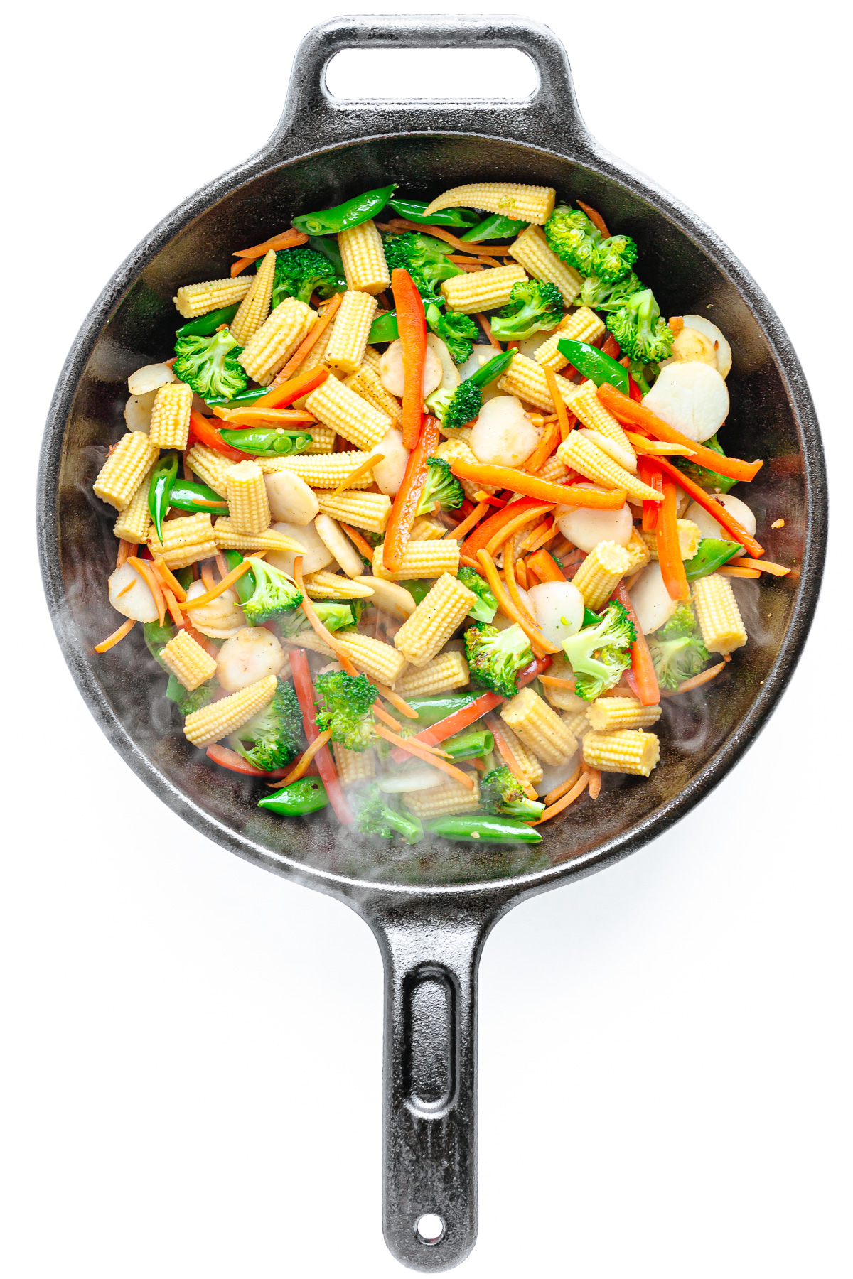 Variety of stir fry vegetables in a cast iron skillet.