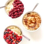 Three bowls of Milchreis (German Rice Pudding) with different toppings displayed on a white background.