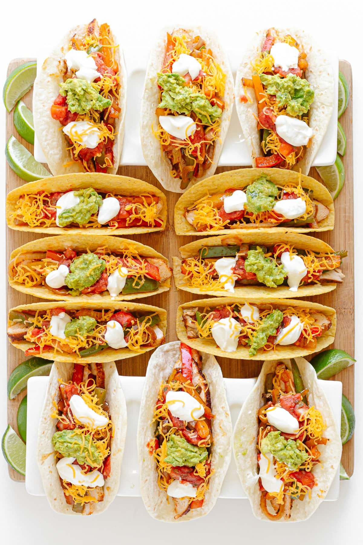 A taco board featuring a mix of soft and hard shell chicken fajita tacos.