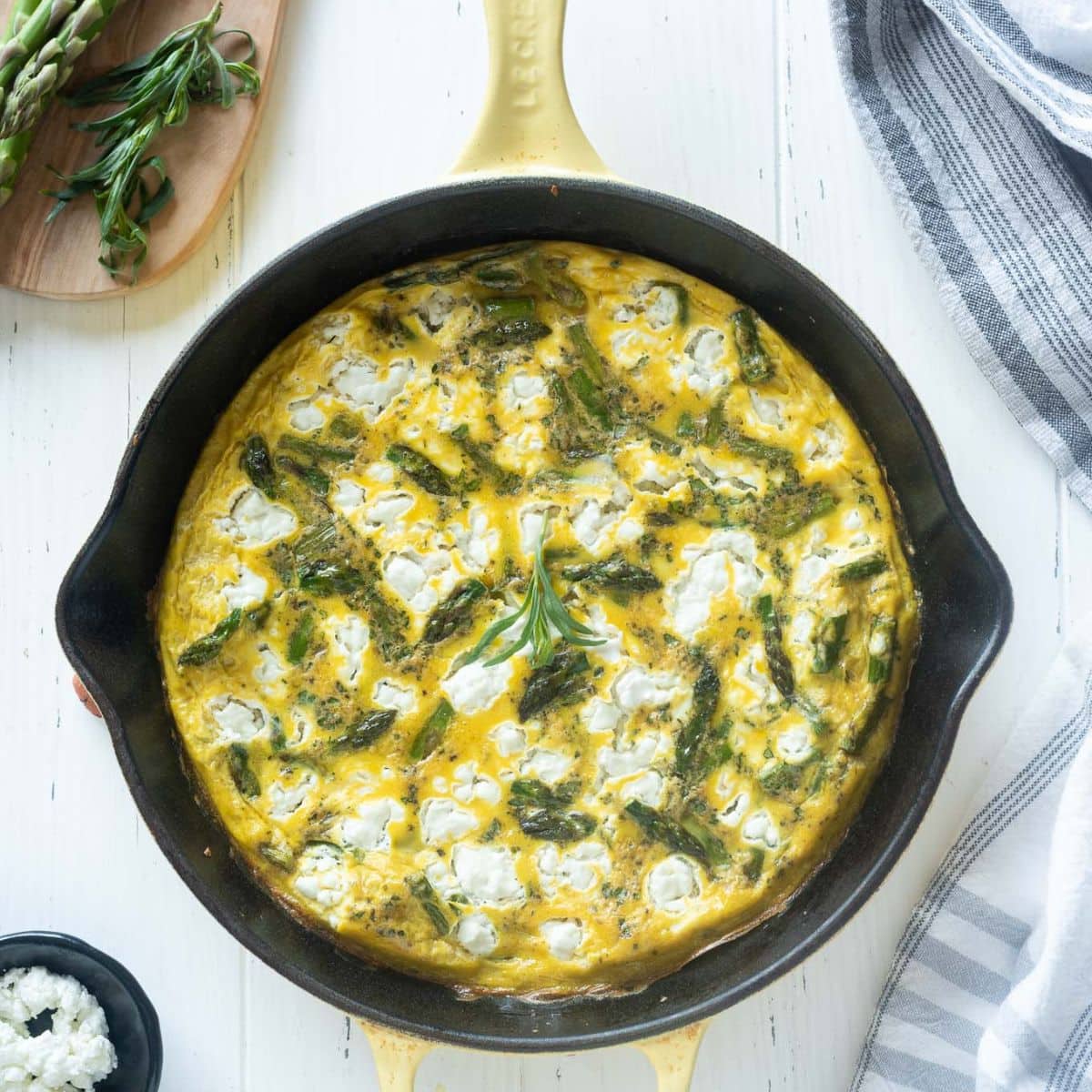 Asparagus frittata with goat cheese in a cast iron skillet.