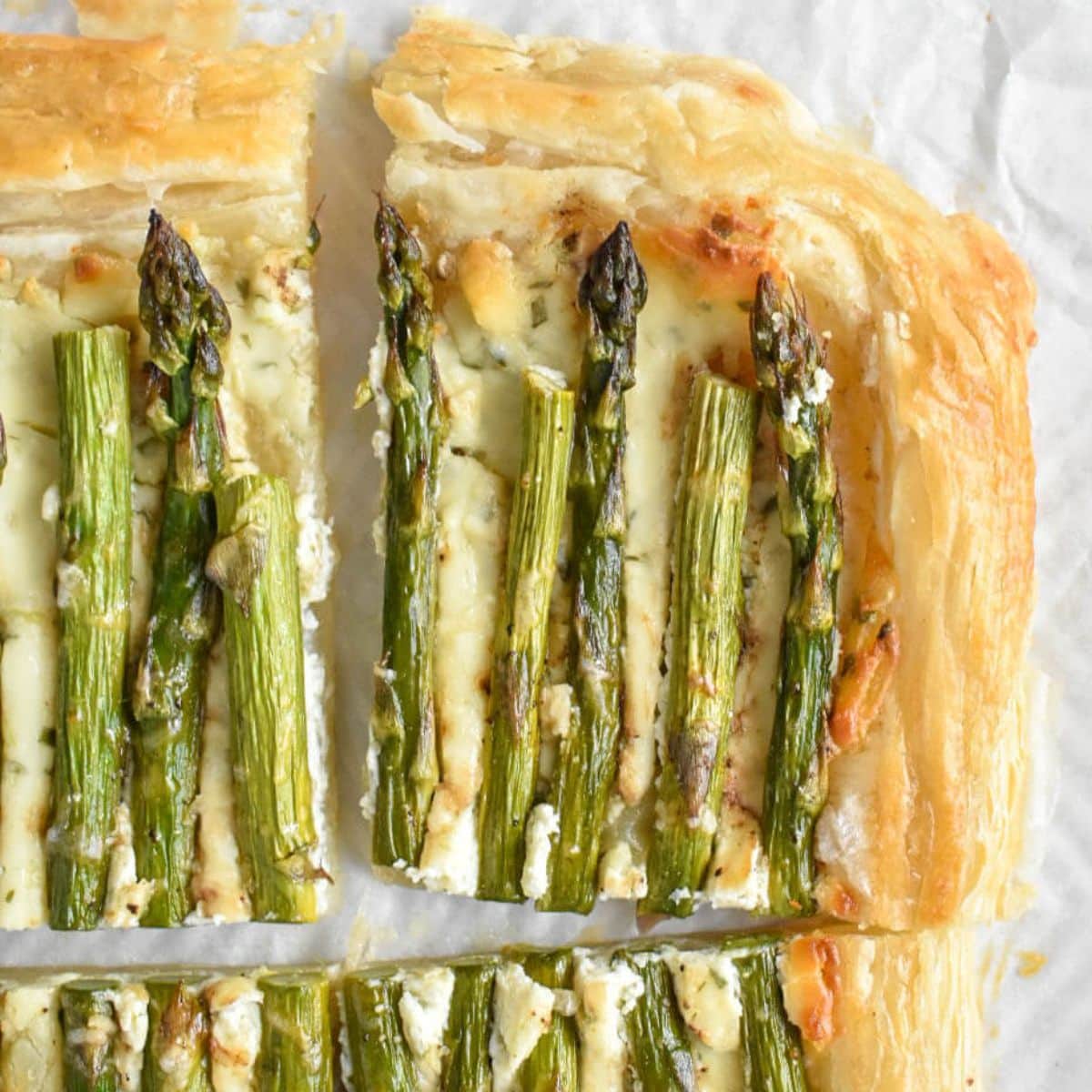 Closeup of a slice of asparagus puff pastry tart.