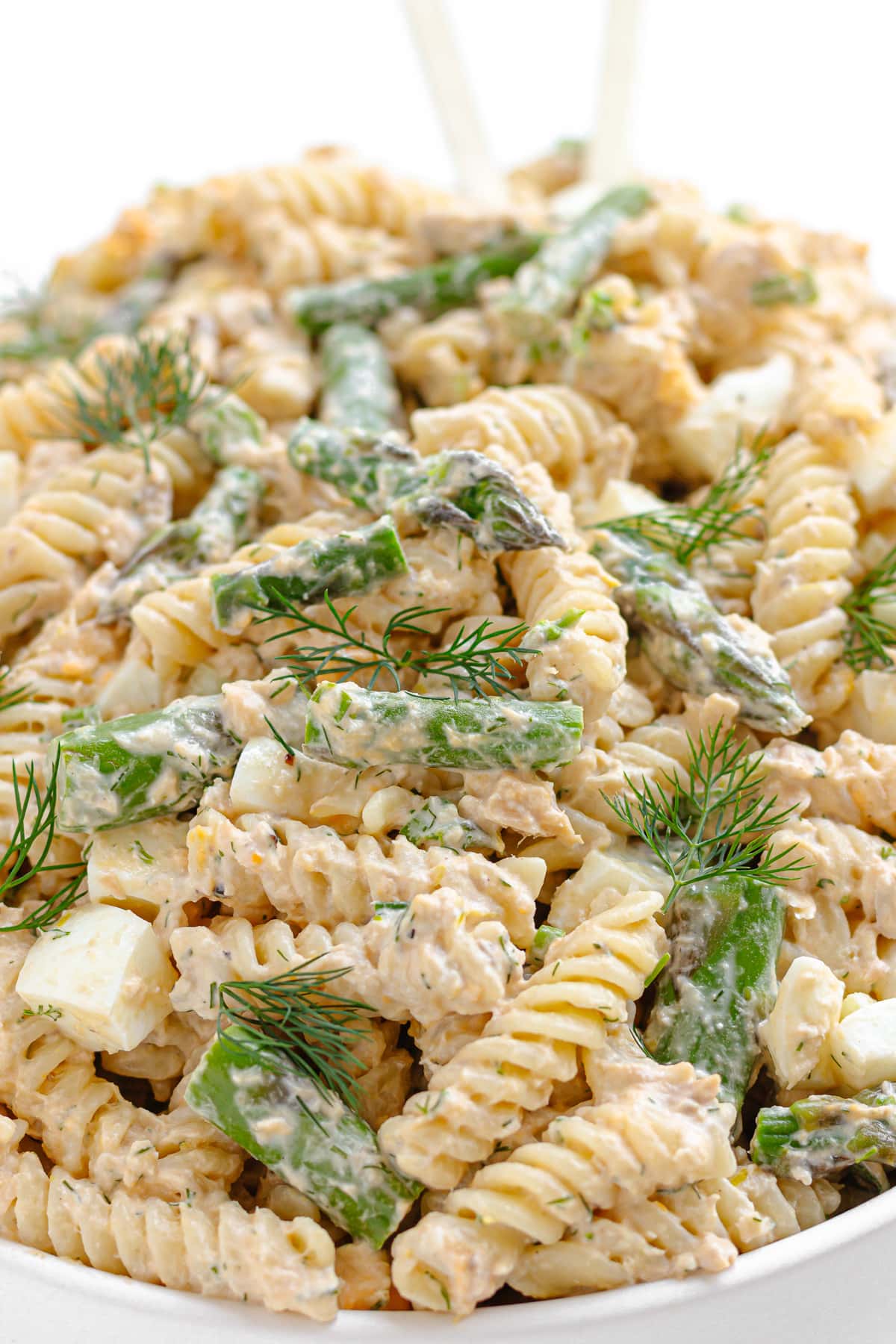 Creamy salmon pasta salad piled up in a white serving dish.
