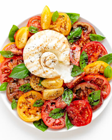 Burrata Caprese on a white serving plate.