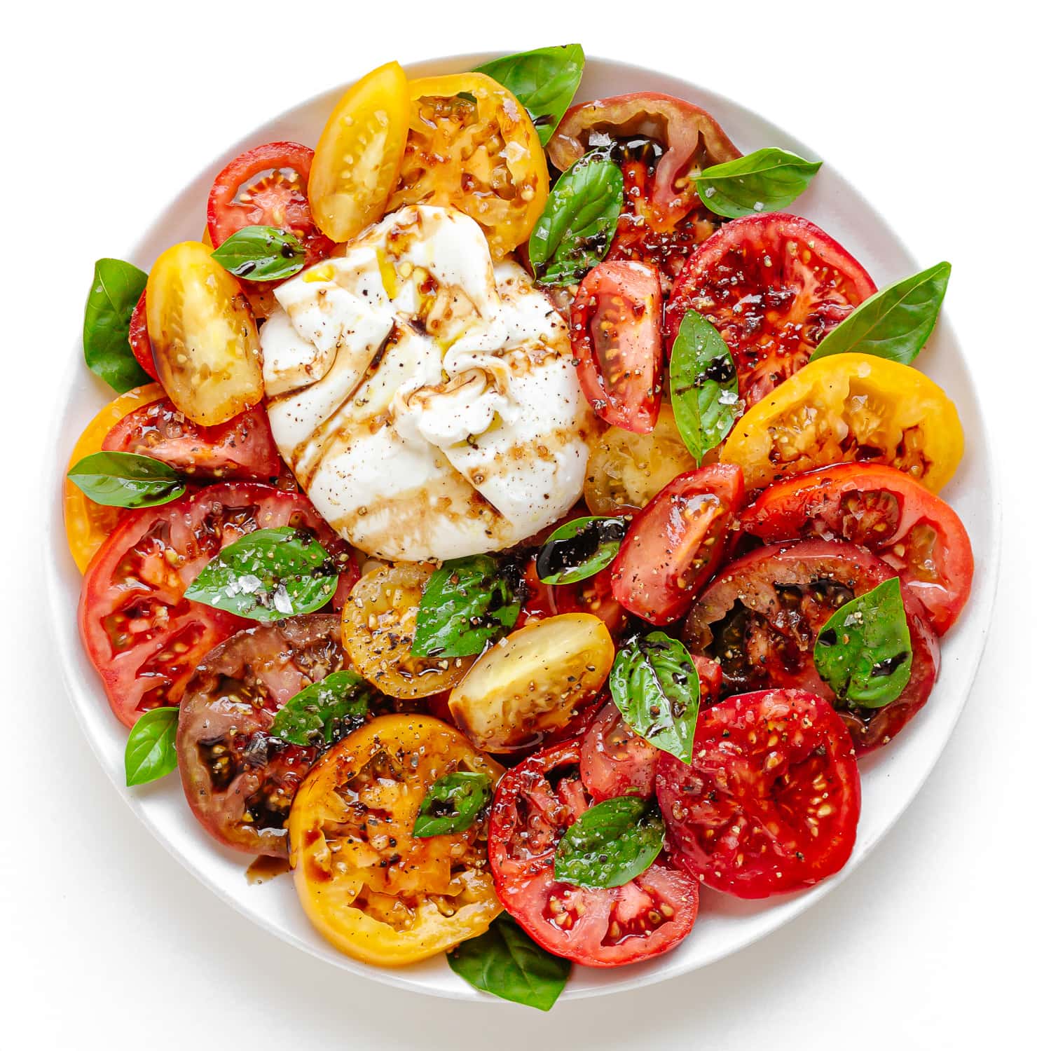 Burrata Caprese Salad on a white serving plate.