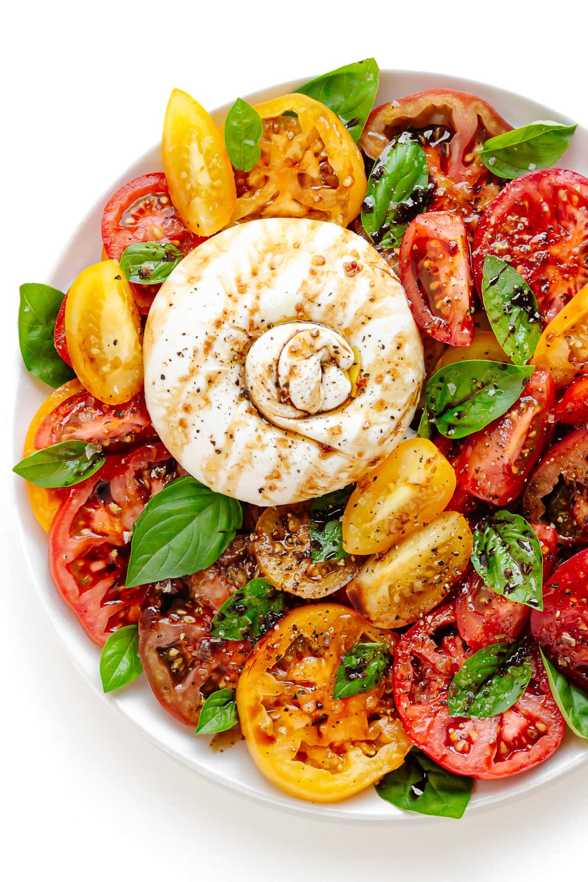 Burrata Caprese Salad on a white plate.