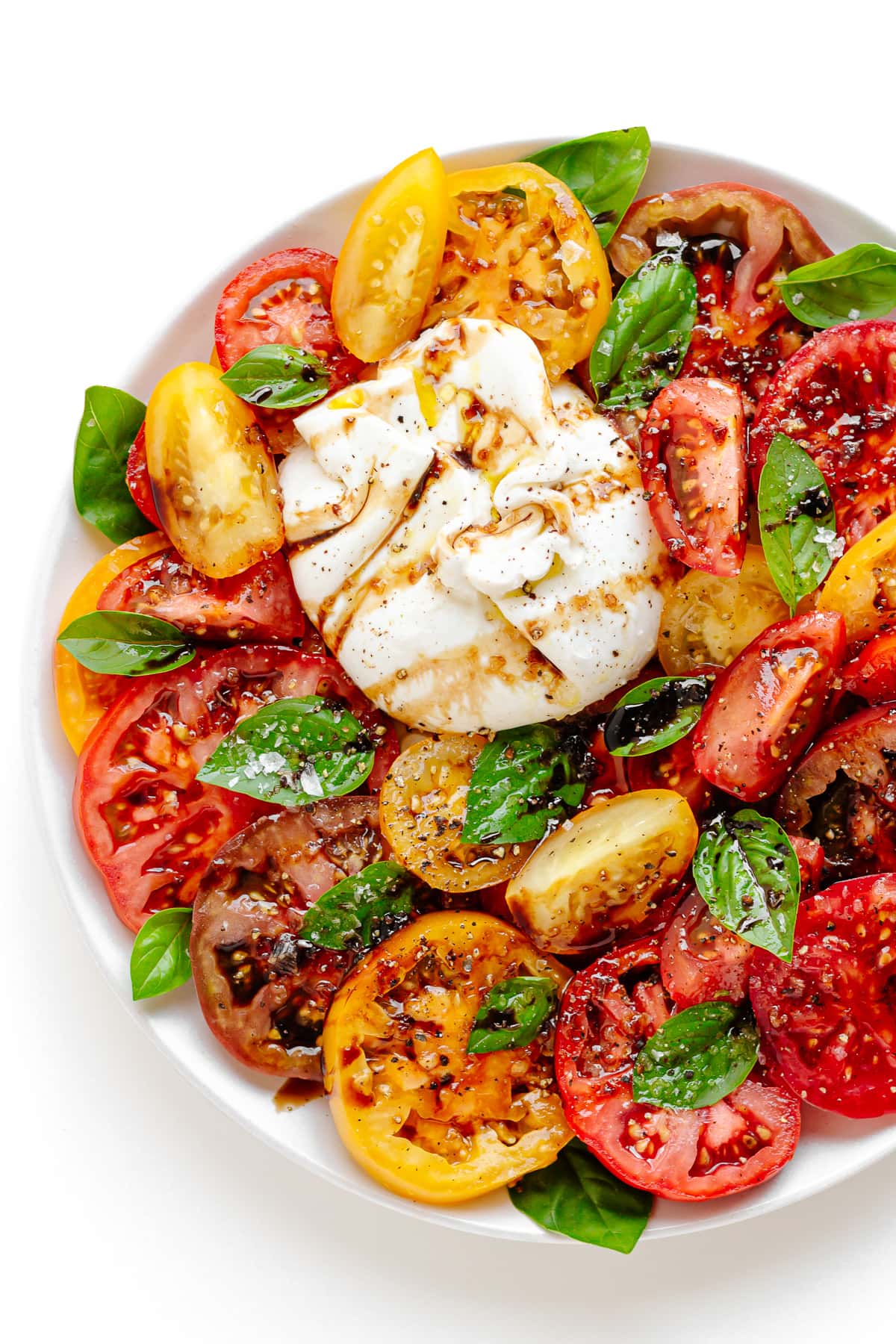 Burrata Caprese assembled on a white plate.