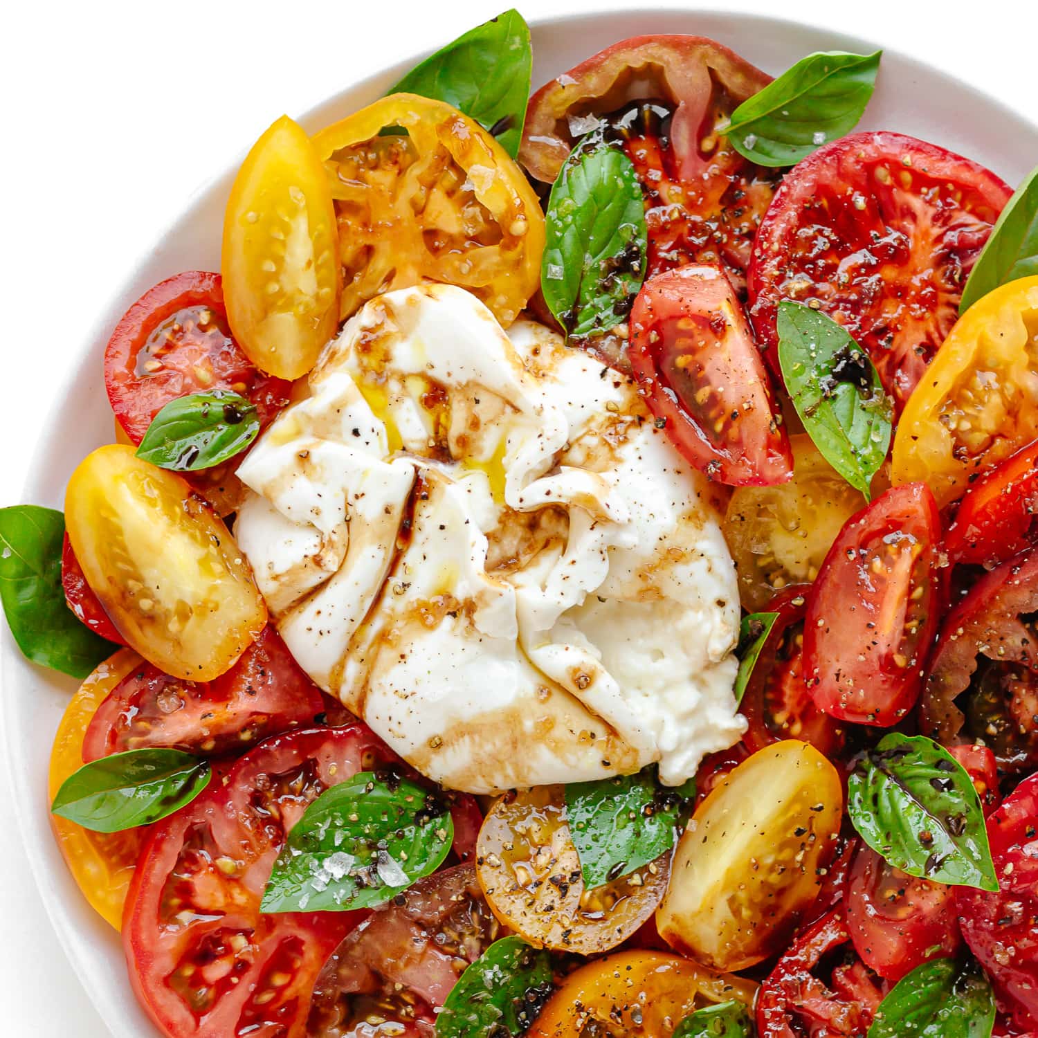 Closeup of Burrata Caprese on a white plate