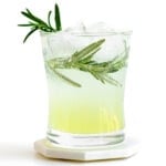 Glass of limoncello tonic garnished with fresh rosemary.