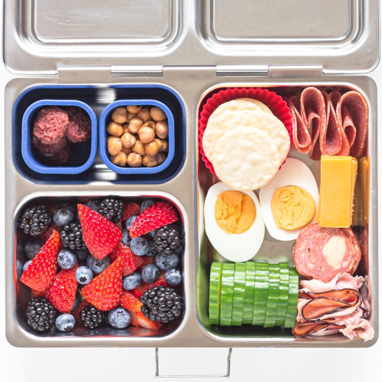 Homemade lunchables in a stainless steel bento-style lunch box.