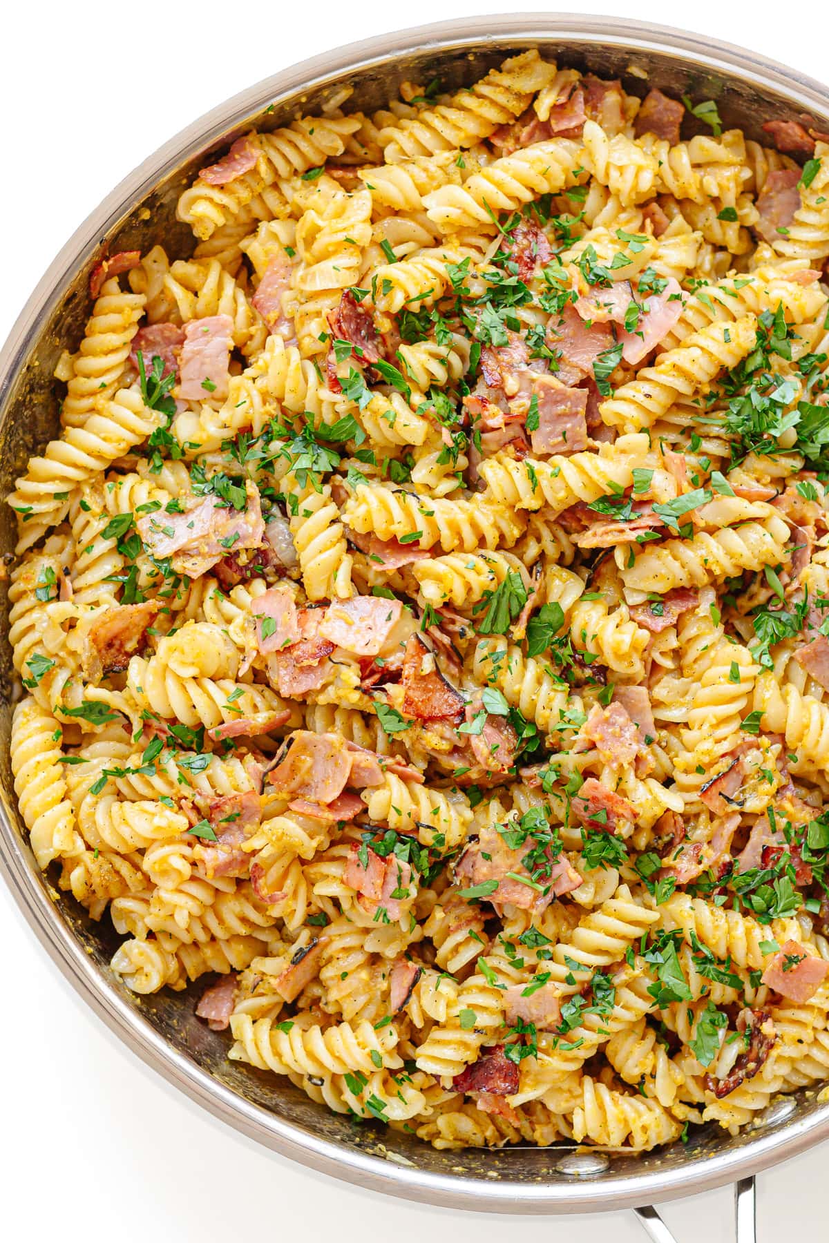 German ham and egg pasta in a stainless steel skillet.