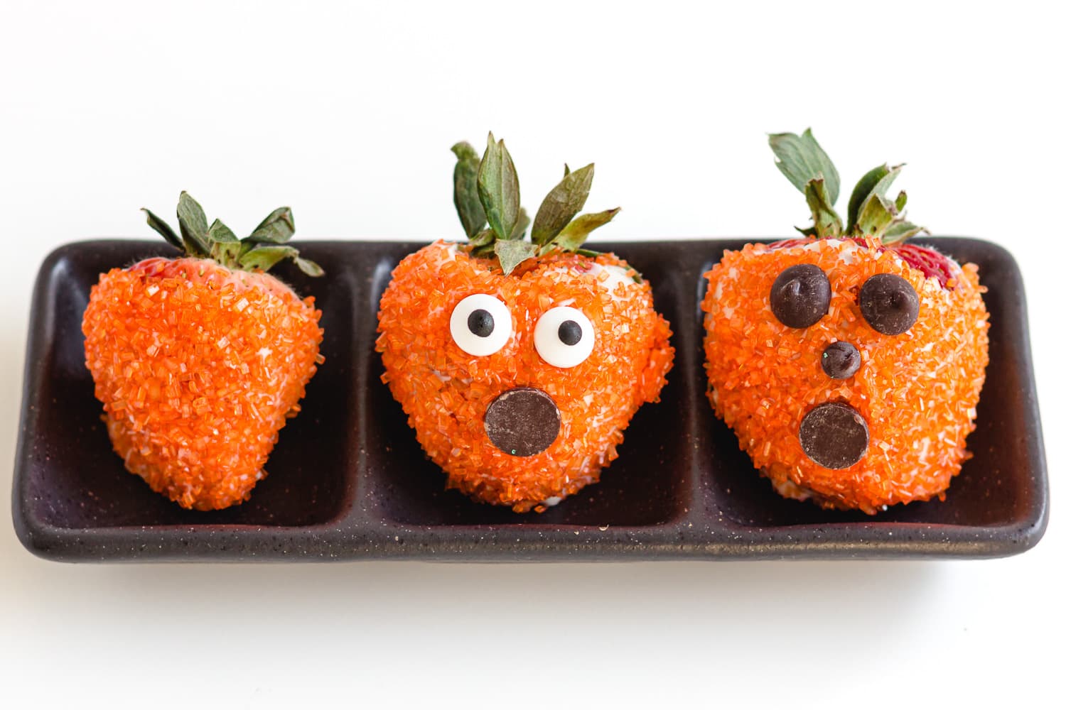 Three different Halloween pumpkin strawberries.