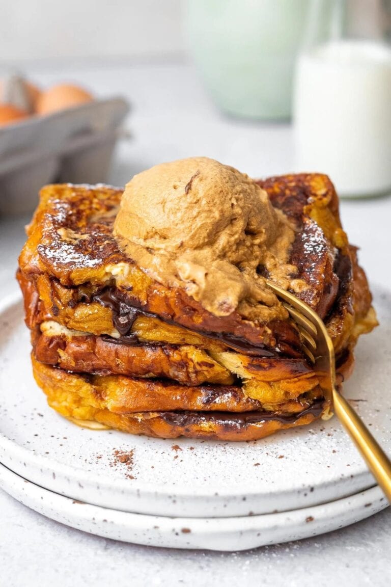 Chocolate coffee brioche french toast on a plate with a gold colored fork.