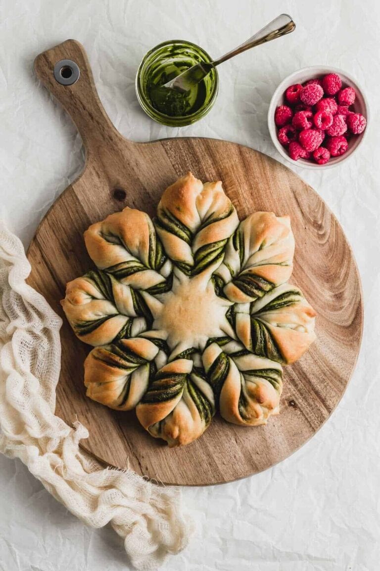 A matcha chocolate star bread sitting on a circular wooden serving board.