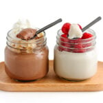 Two glass jars of coconut jelly with spoons scooping some out, one chocolate flavored and one vanilla flavored.