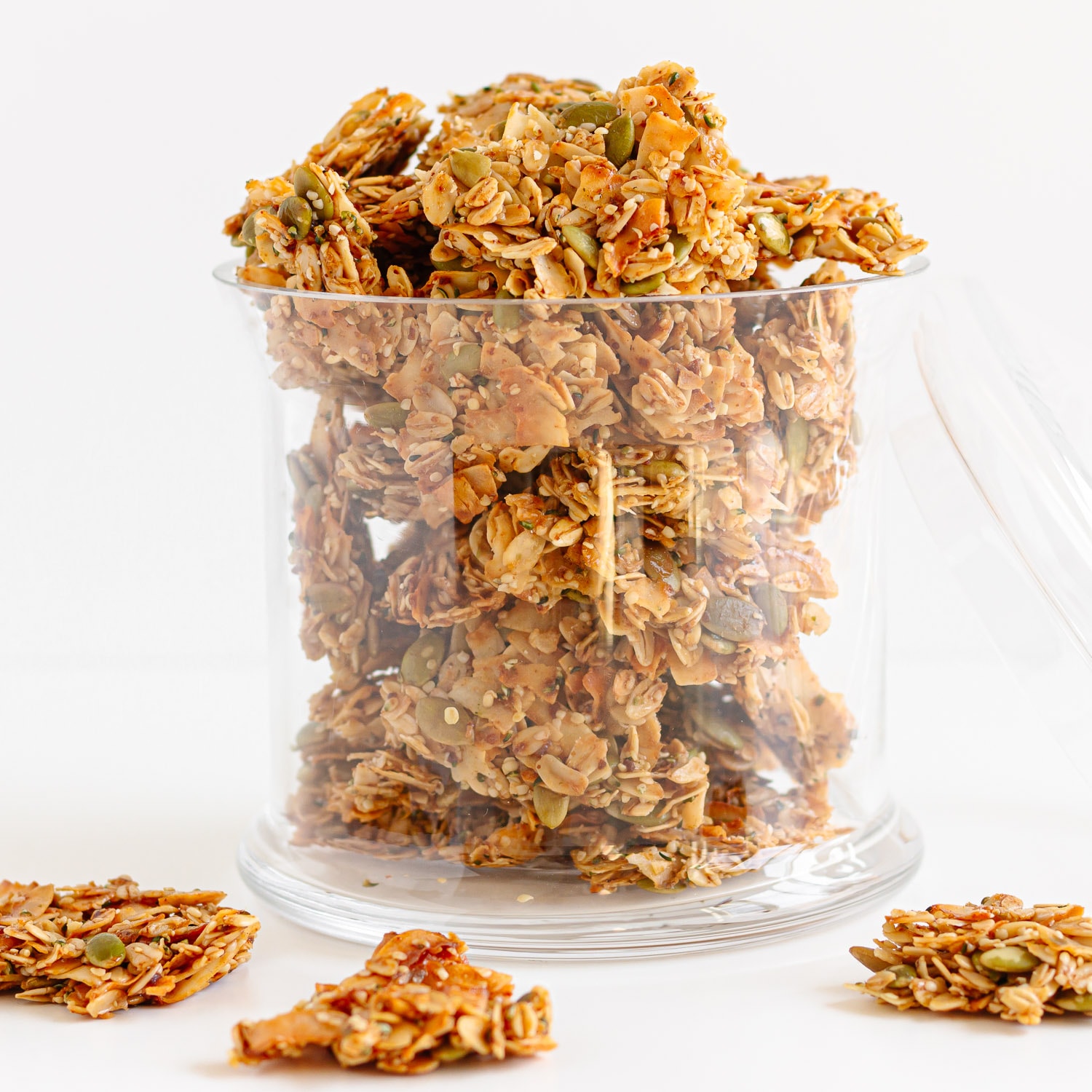 Nut free coconut granola in a glass jar with lid resting next to it.